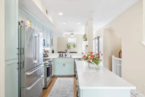 a kitchen with kitchen island a sink stainless steel appliances and cabinets