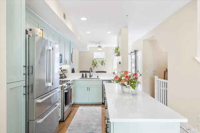 a kitchen with kitchen island a sink stainless steel appliances and cabinets