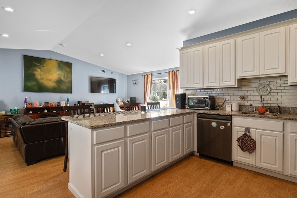 481 Buck Island Road, Unit 11F Yarmouth, MA 02673 - Photo 12 of 28 a kitchen with stainless steel appliances granite countertop a stove top oven a sink dishwasher and a microwave oven with white cabinets
