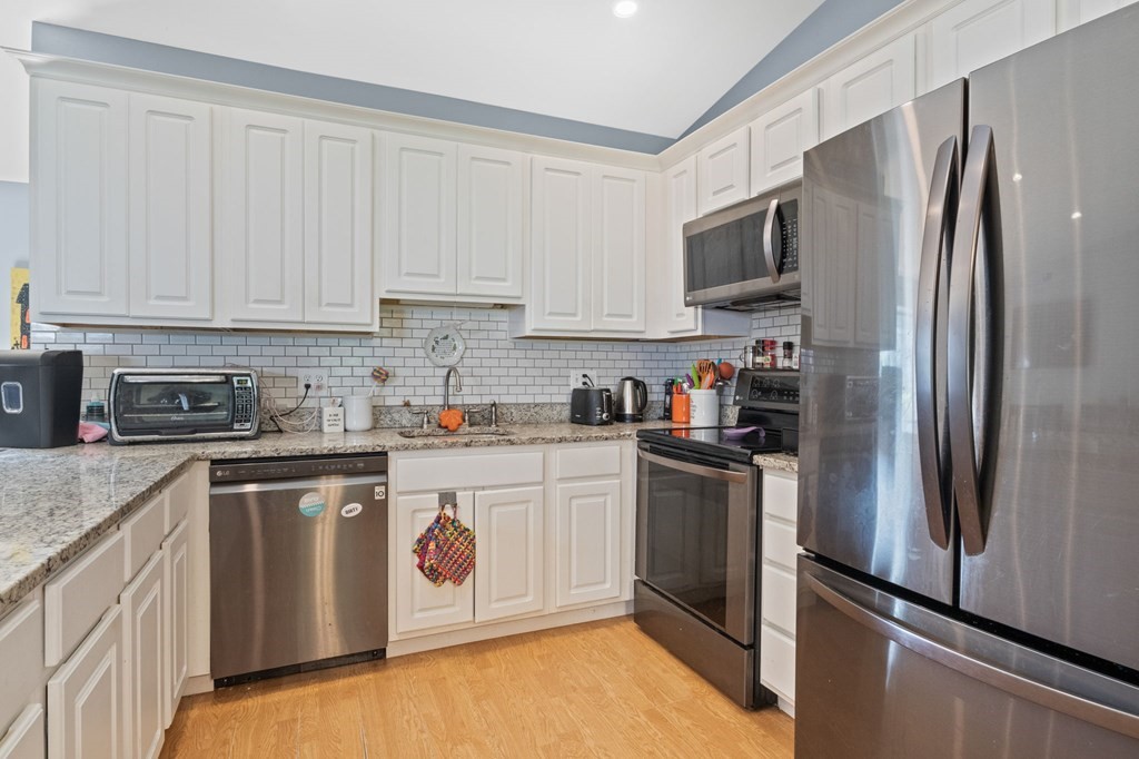 481 Buck Island Road, Unit 11F Yarmouth, MA 02673 - Photo 13 of 28 a kitchen with stainless steel appliances granite countertop a refrigerator a stove a sink and white cabinets