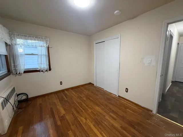 a view of a room with wooden floor and cabinet