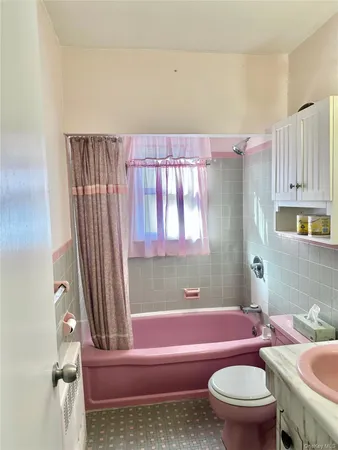 a bathroom with a granite countertop bathtub sink vanity mirror and toilet