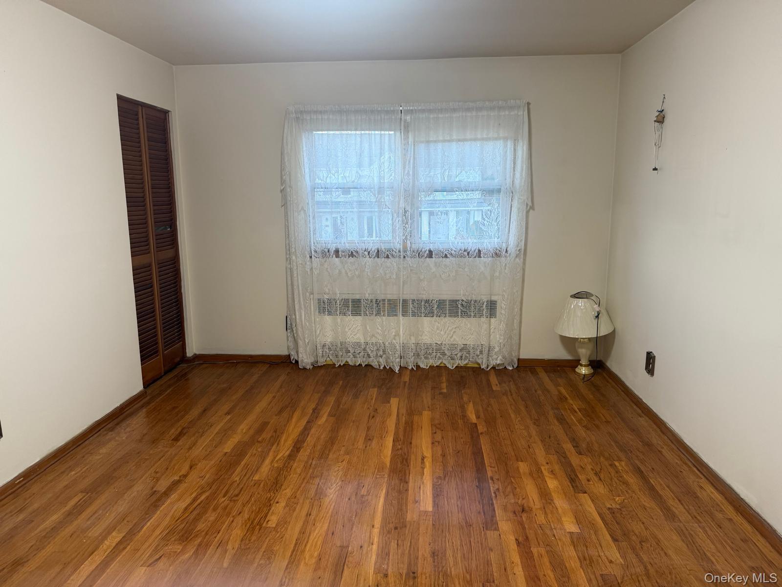 110 Evergreen Avenue, Unit 2 Lynbrook, NY 11563 - Photo 3 of 18 an empty room with wooden floor and window