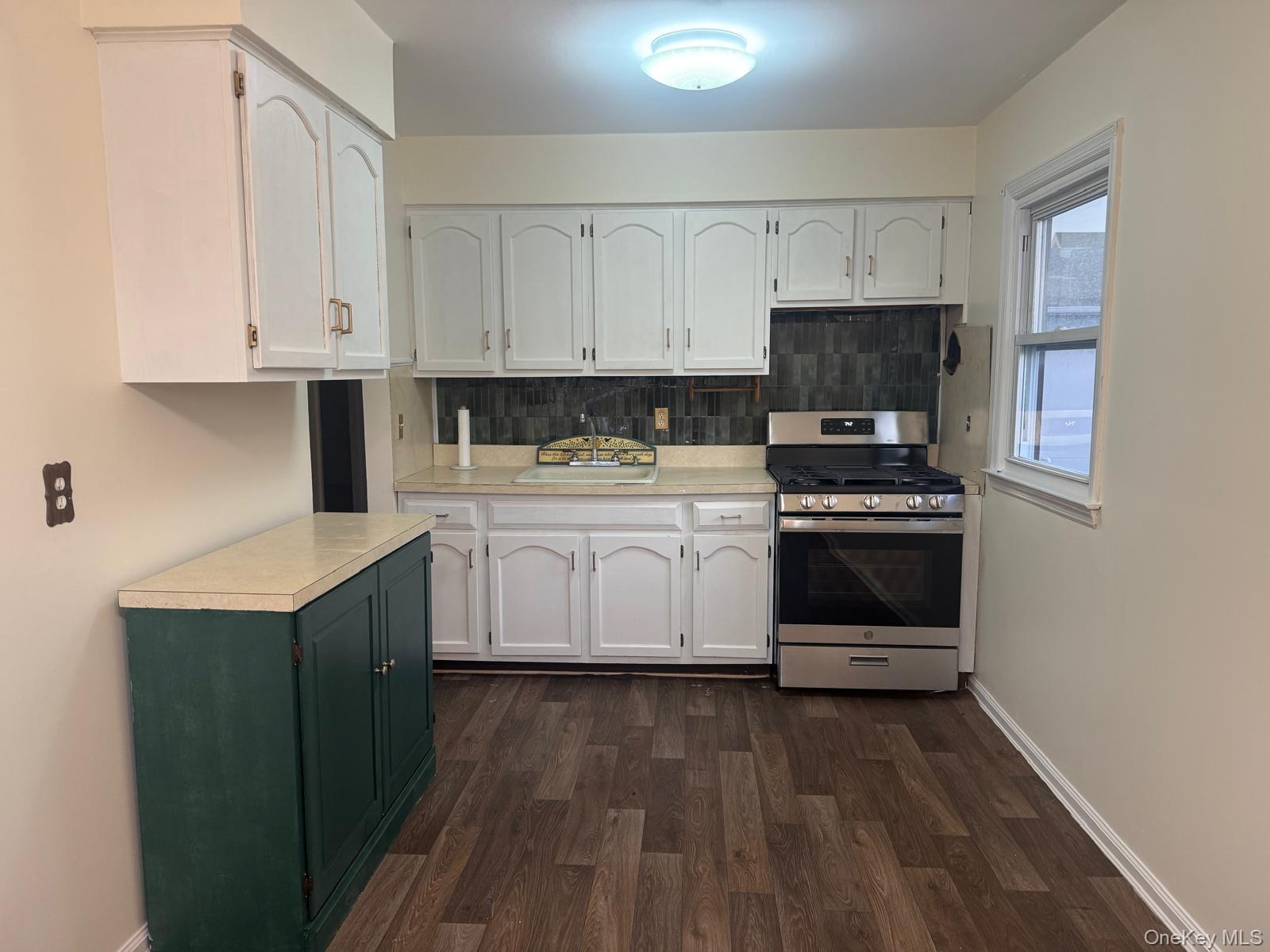 110 Evergreen Avenue, Unit 2 Lynbrook, NY 11563 - Photo 5 of 18 a kitchen with stainless steel appliances a white stove top oven and white cabinets