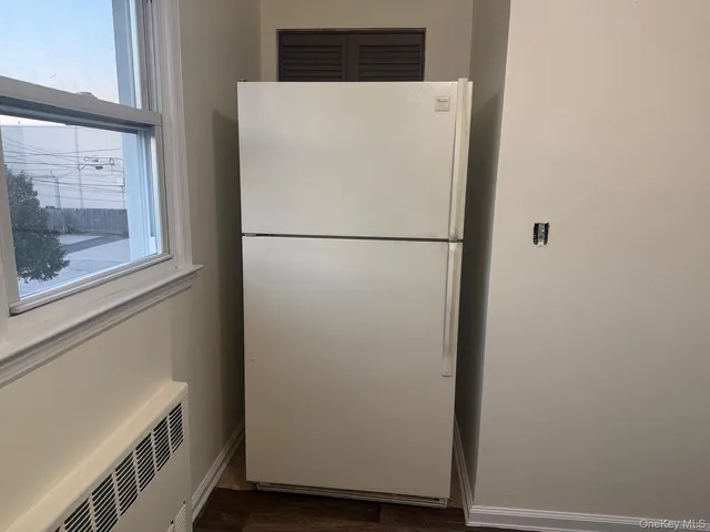 a white refrigerator freezer sitting next to a white wall