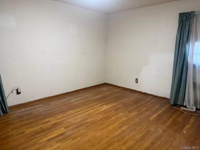 an empty room with wooden floor and entrance