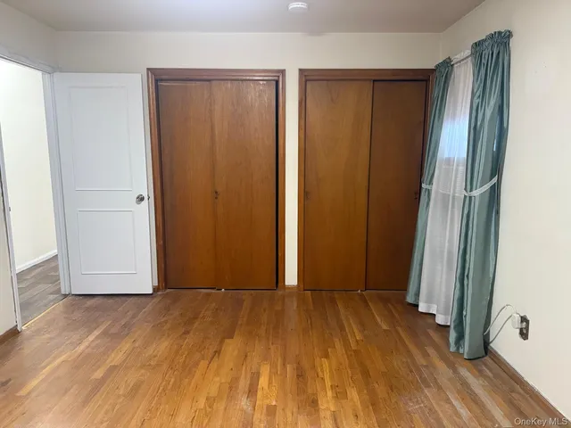 an empty room with wooden floor and a window