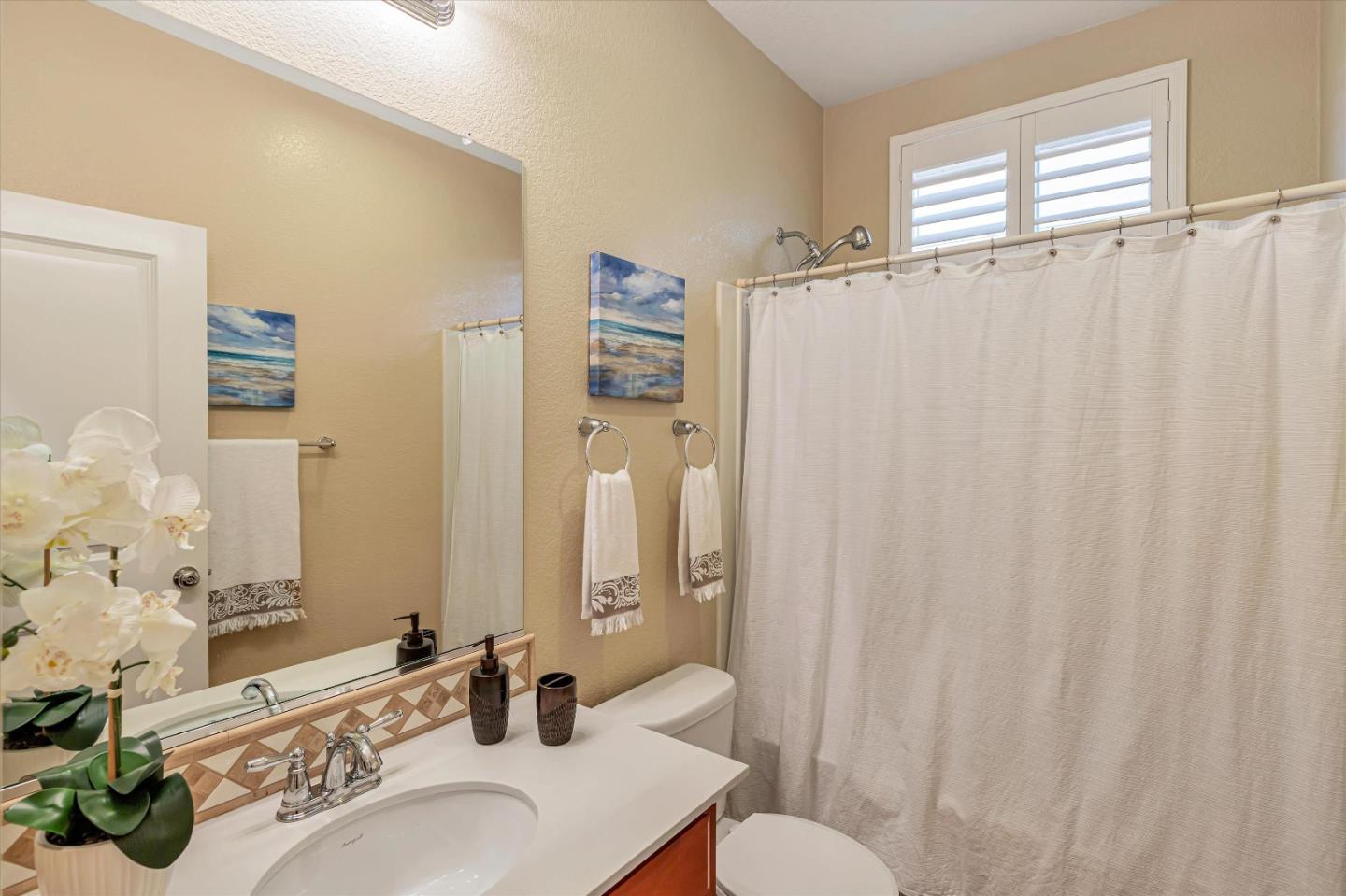 9545 Grande Drive Gilroy, CA 95020 - Photo 20 of 28 a bathroom with a sink a toilet and shower curtain