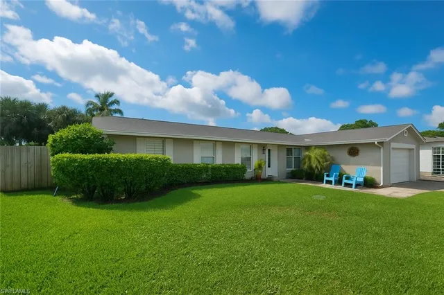 a front view of a house with a garden and yard