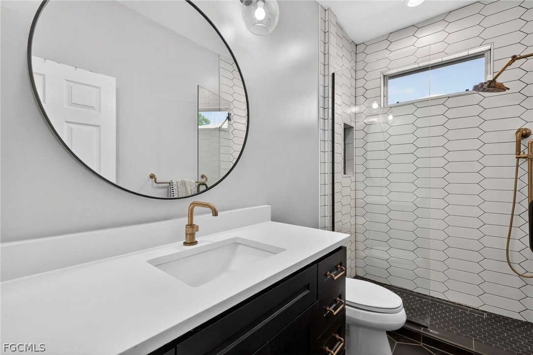 22866 Forest Ridge Drive Estero, FL 33928 - Photo 24 of 38 a bathroom with a sink a toilet and a mirror