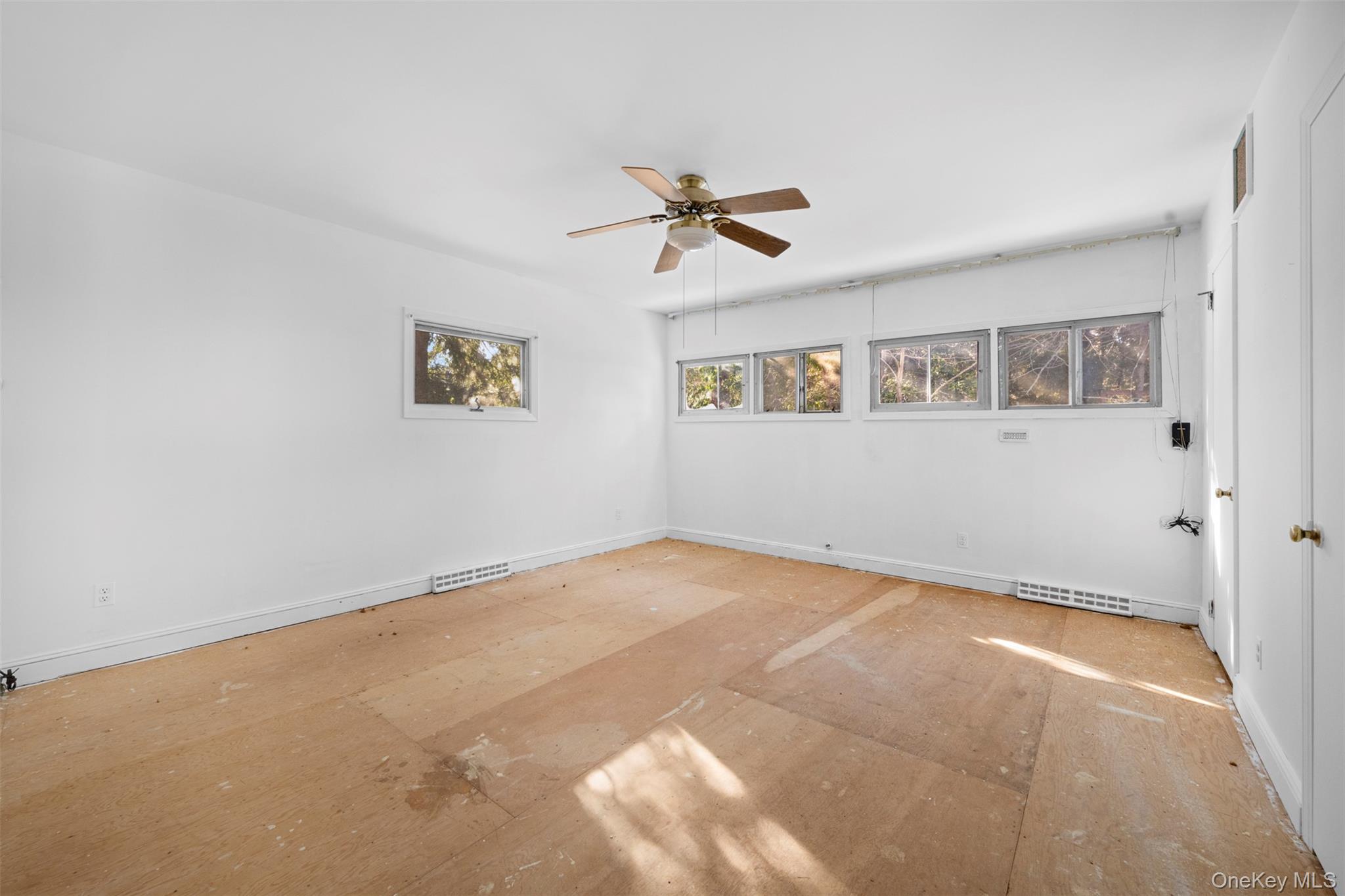 66 Deepdale Drive Great Neck, NY 11021 - Photo 18 of 48 an empty room with windows and ceiling fan view