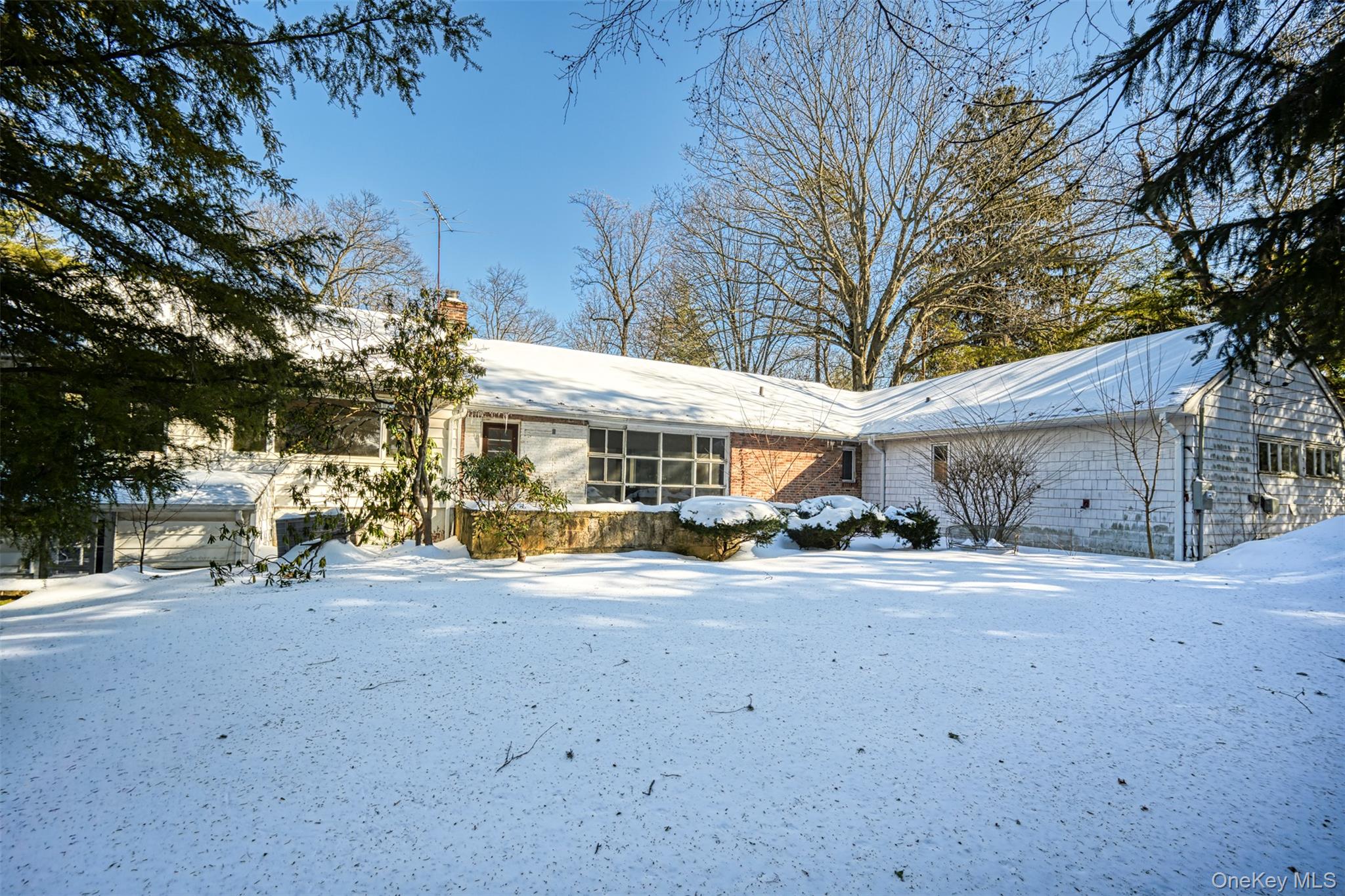 66 Deepdale Drive Great Neck, NY 11021 - Photo 44 of 48 a view of a house with a yard covered with snow in front of house