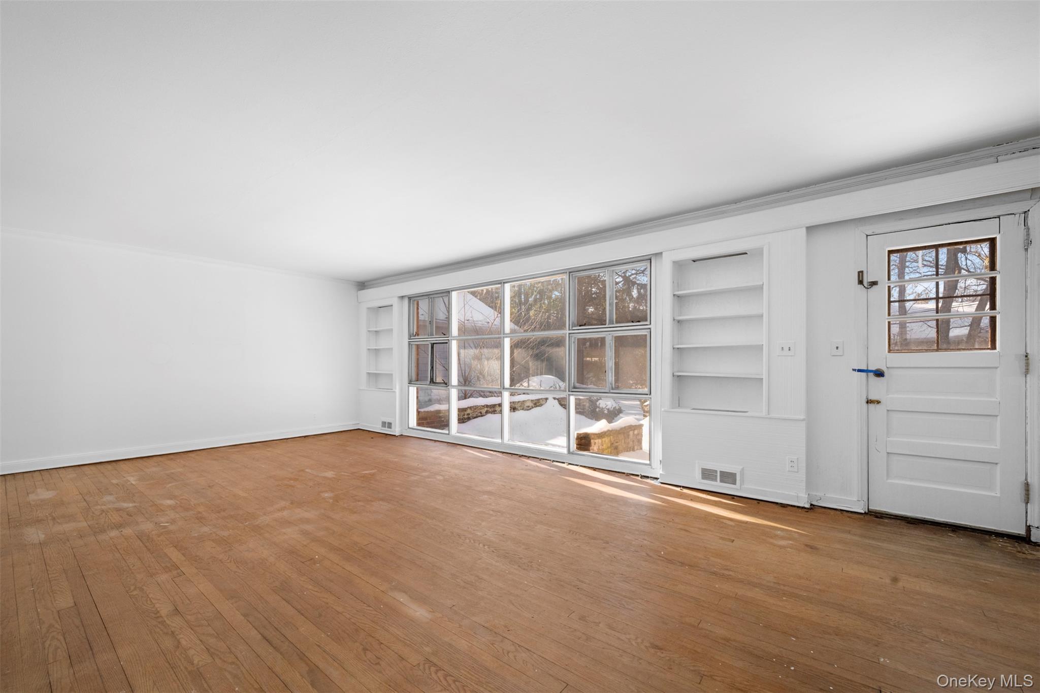 66 Deepdale Drive Great Neck, NY 11021 - Photo 5 of 48 an empty room with cabinet and windows