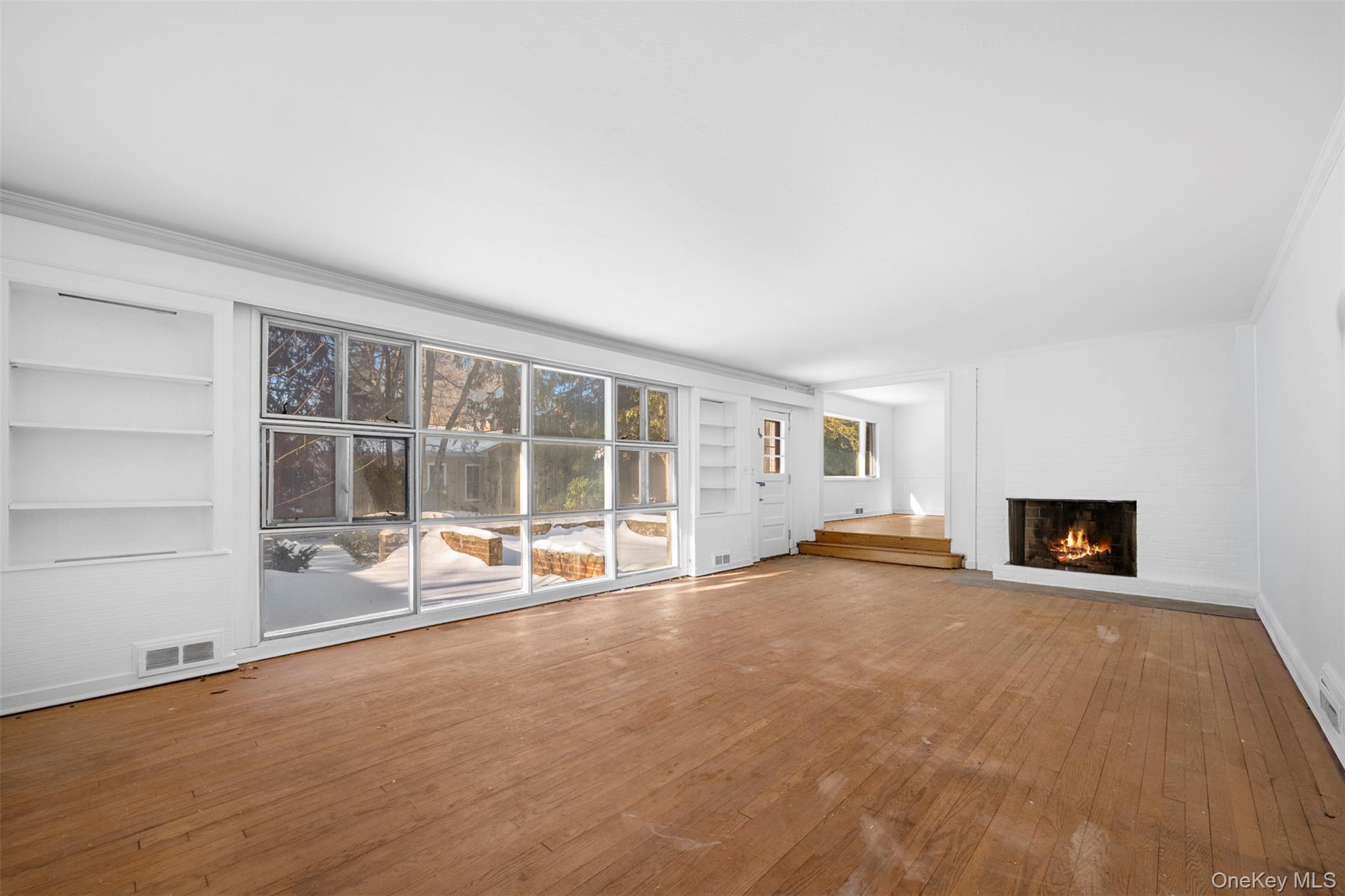 66 Deepdale Drive Great Neck, NY 11021 - Photo 6 of 48 an empty room with a fireplace and large window