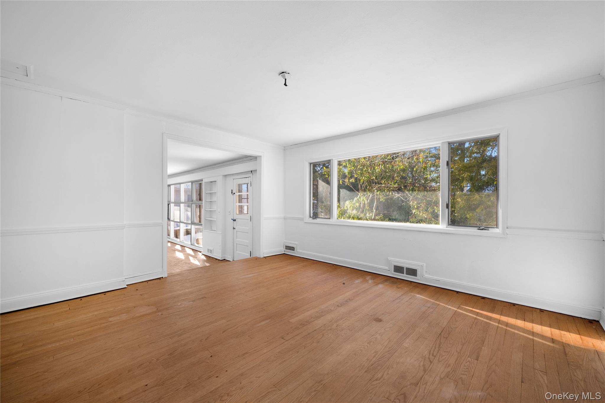 66 Deepdale Drive Great Neck, NY 11021 - Photo 7 of 48 wooden floor in an empty room with a window
