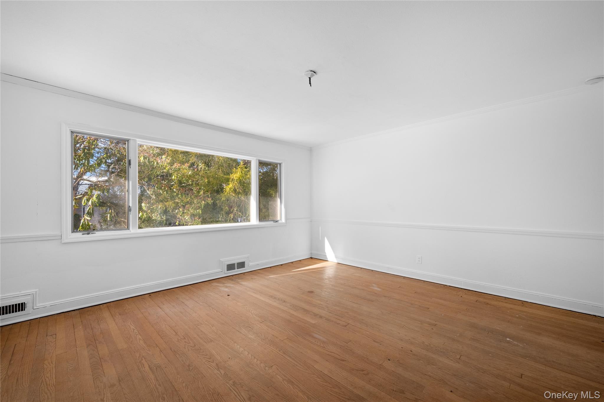 66 Deepdale Drive Great Neck, NY 11021 - Photo 8 of 48 an empty room with wooden floor and windows