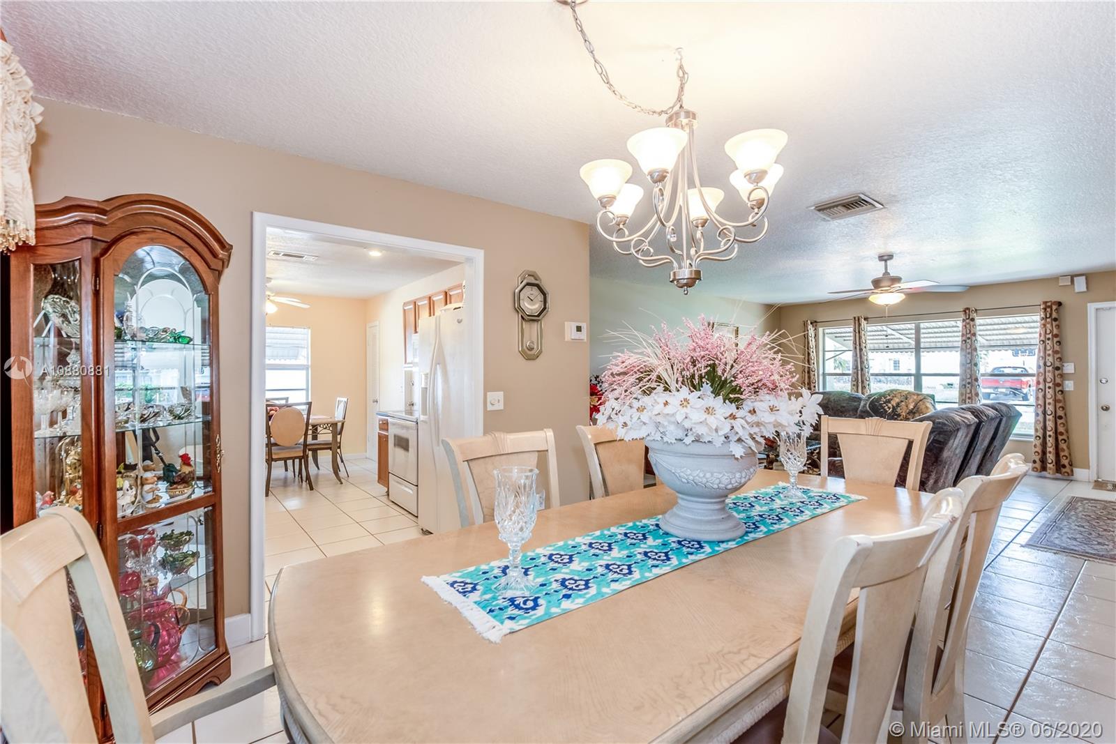 8884 Southwest 6th Street Boca Raton, FL 33433 - Photo 17 of 39 a view of a dining room with furniture a chandelier and wooden floor