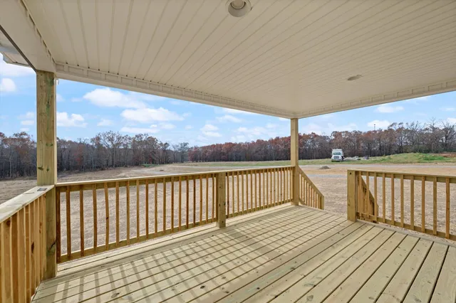 a view of balcony with wooden floor and fence