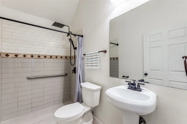 a bathroom with a sink toilet and shower