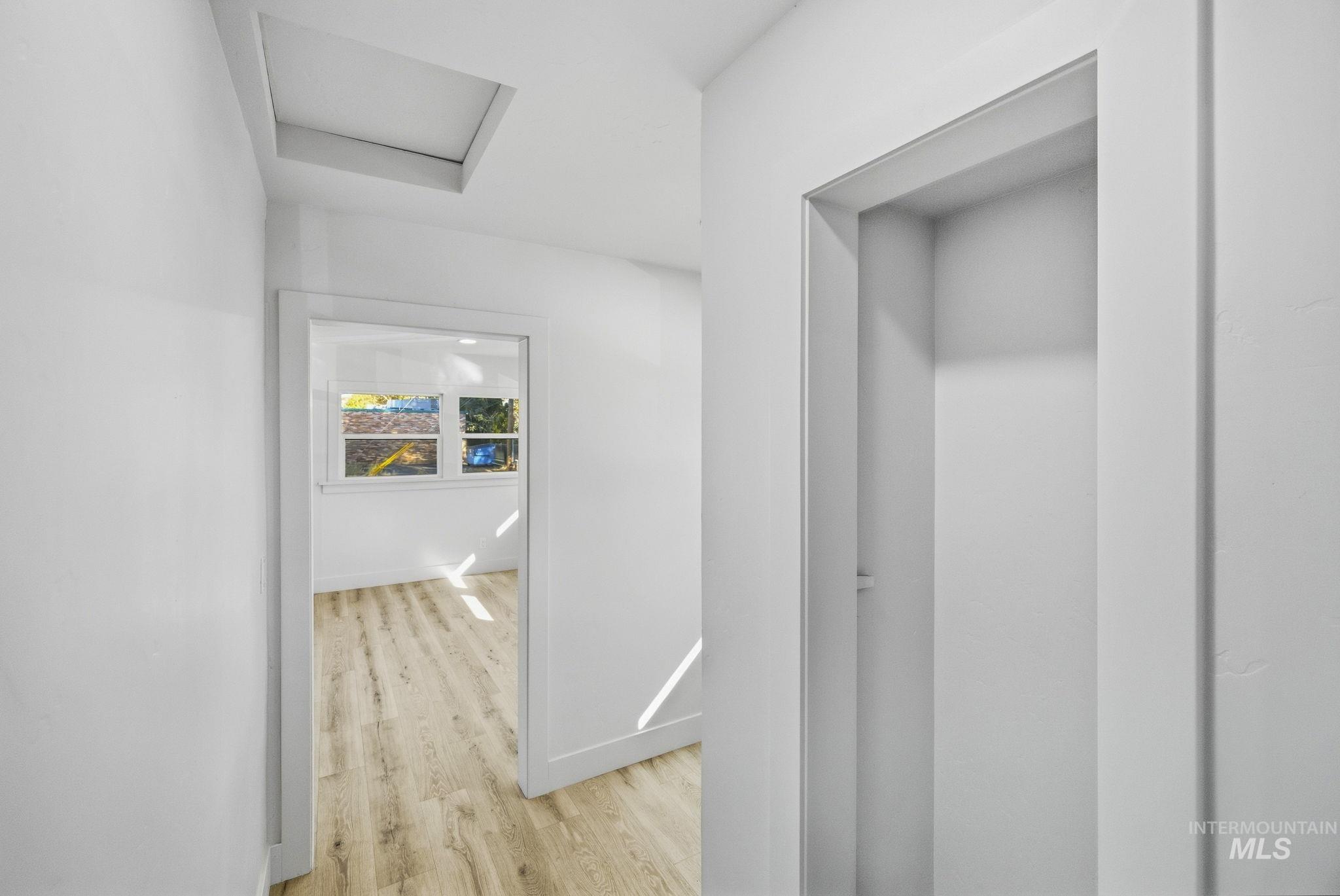3113 West Overland Road Boise, ID 83705 - Photo 31 of 40 White interior walls, wood-finish flooring, interior window, and recessed ceiling access panel