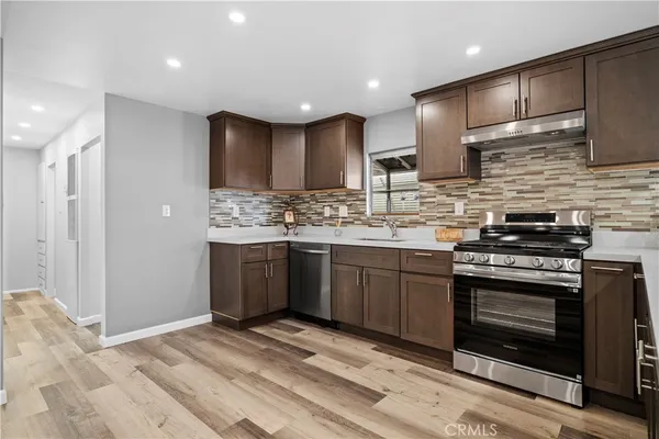 a kitchen with stainless steel appliances granite countertop a stove sink and cabinets