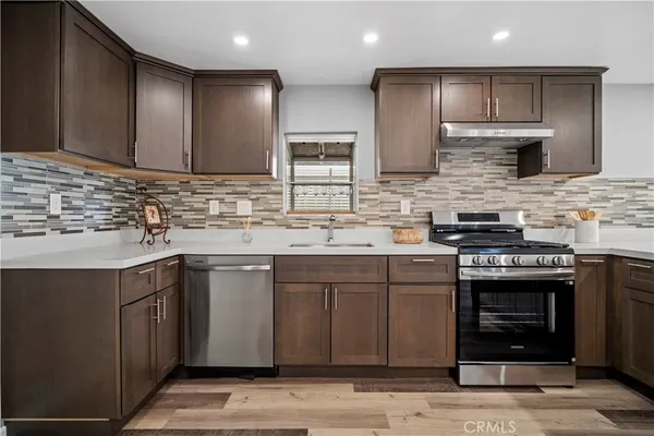 a kitchen with stainless steel appliances granite countertop a sink stove and refrigerator