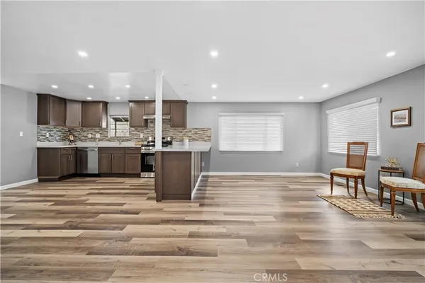 a view of kitchen with kitchen island a sink stainless steel appliances and cabinets
