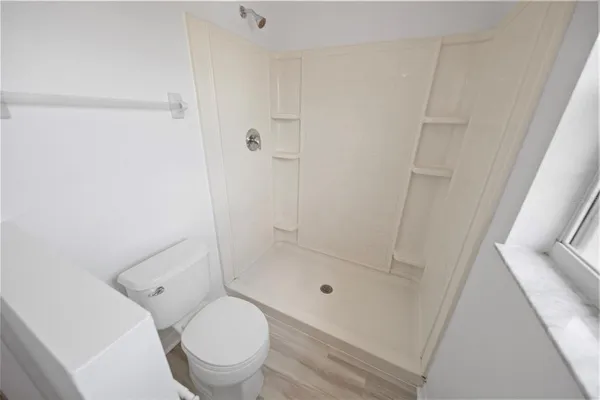 a bathroom with a toilet and a shower