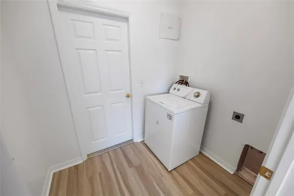 a utility room with wooden floor washer and dryer