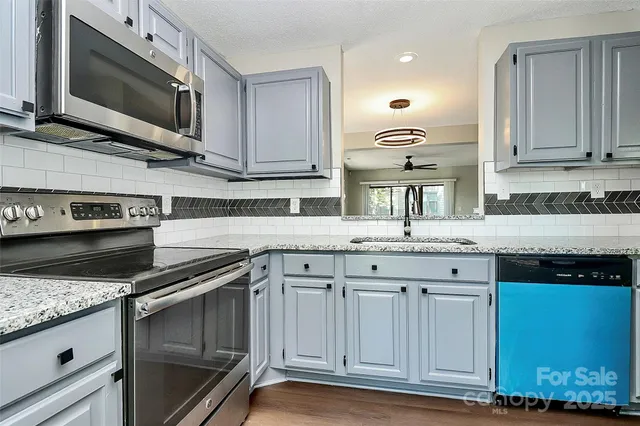 a kitchen with stainless steel appliances granite countertop a sink and a stove
