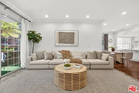 a living room with furniture a window and a chandelier