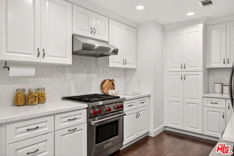 a kitchen with white cabinets and appliances