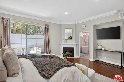 a spacious bedroom with a large bed and a flat screen tv