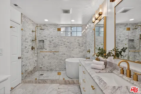 a bathroom with a granite countertop sink mirror and bathtub
