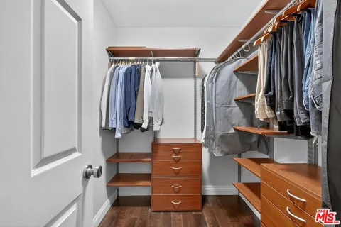 a view of walk in closet with clothes and shoes