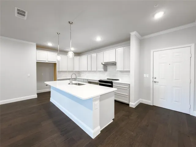 a kitchen with a sink a stove a refrigerator and a window