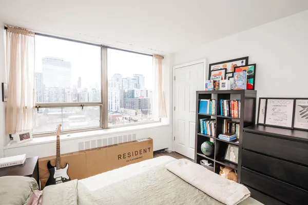a living room with a large window and a book shelf