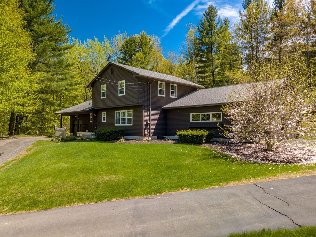 843 Blandford Road Russell, MA 01071 - Photo 2 of 27 a front view of a house with a garden and yard