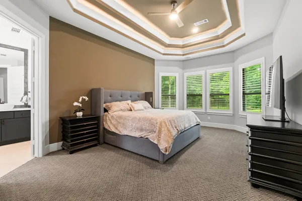 a bed sitting in a spacious bedroom next to a window