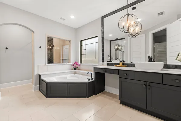 a spacious bathroom with a sink a large mirror and a bathtub