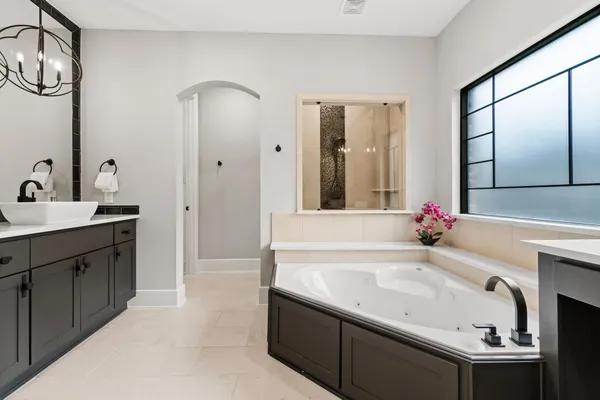 a bathroom with a tub sink and mirror