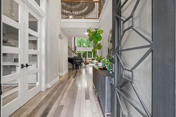 a view of a hallway with wooden floor and a potted plant