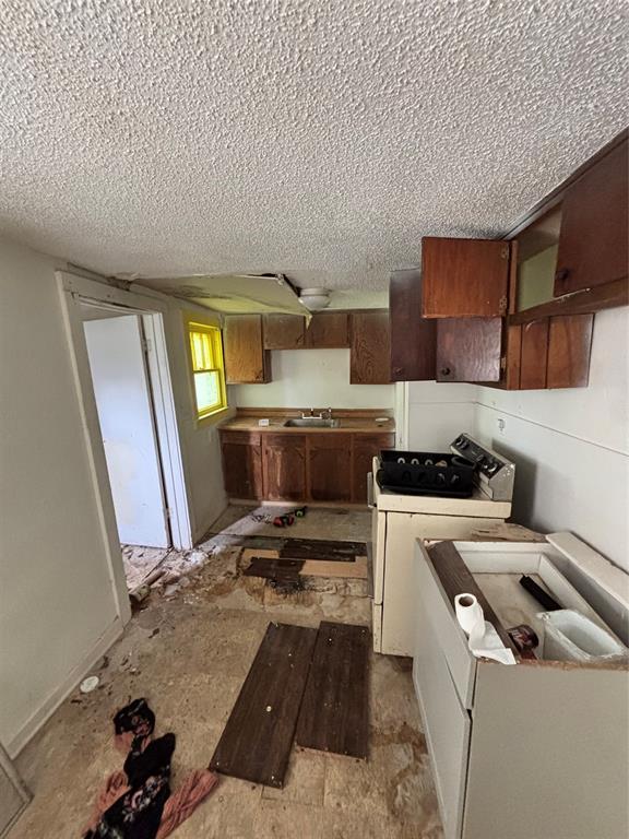 1918 North 6th Street, Unit R Wichita Falls, TX 76301 - Photo 8 of 14 a kitchen with a stove a sink and a refrigerator