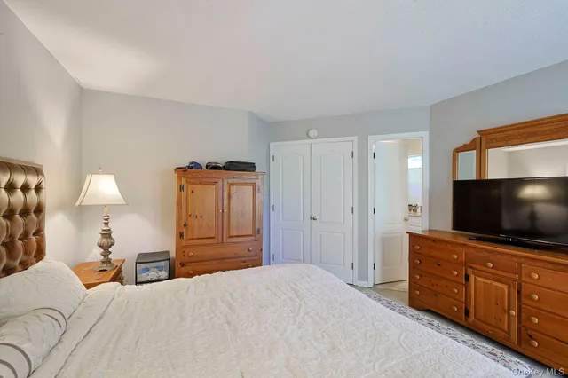 a bedroom with a bed and flat screen tv