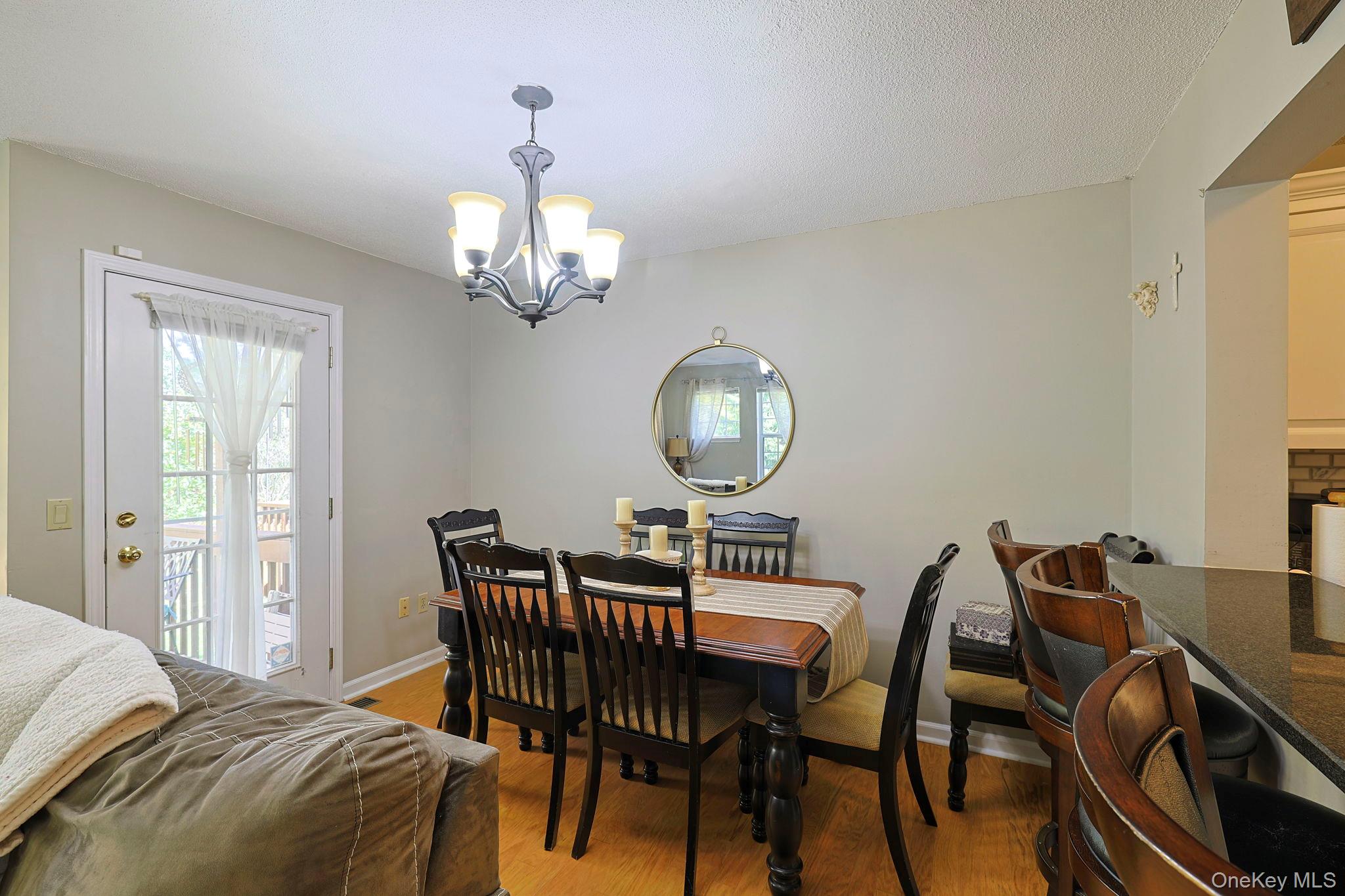 209 Crestwood Court Fishkill, NY 12524 - Photo 9 of 23 a view of a dining room with furniture a chandelier and wooden floor
