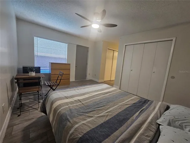 a bedroom with a bed and a ceiling fan