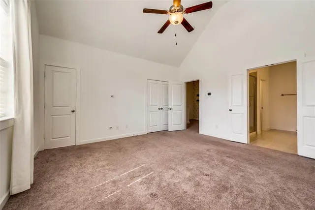 an empty room with closet and windows
