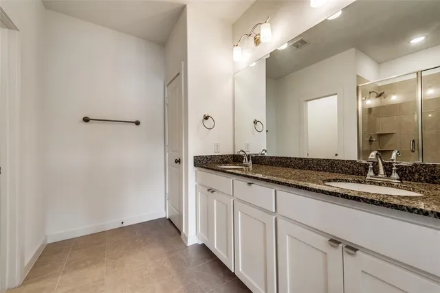 a bathroom with a double vanity sink and a mirror