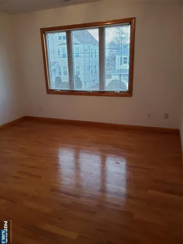 a view of a room with wooden floor and a window