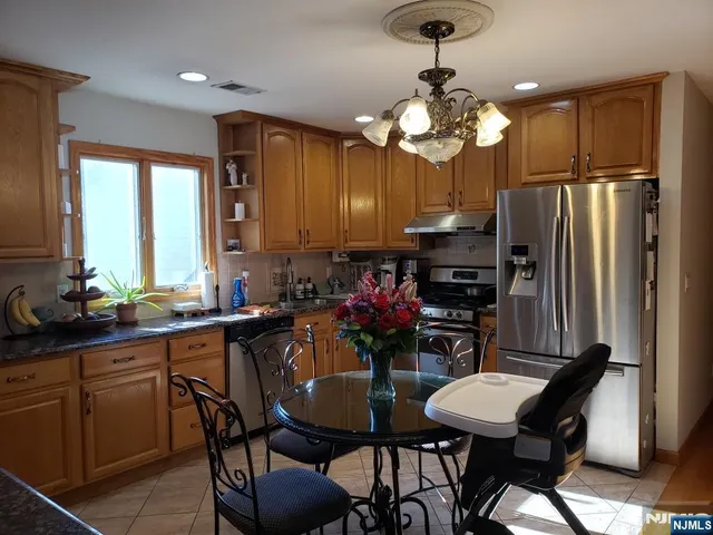 a kitchen with a dining table chairs stainless steel appliances and cabinets